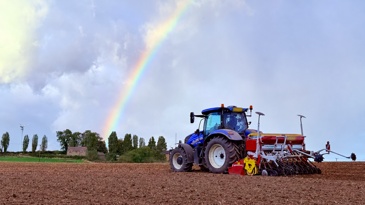 Tractor and seed drill beneath a rainbow at Povey Farm.